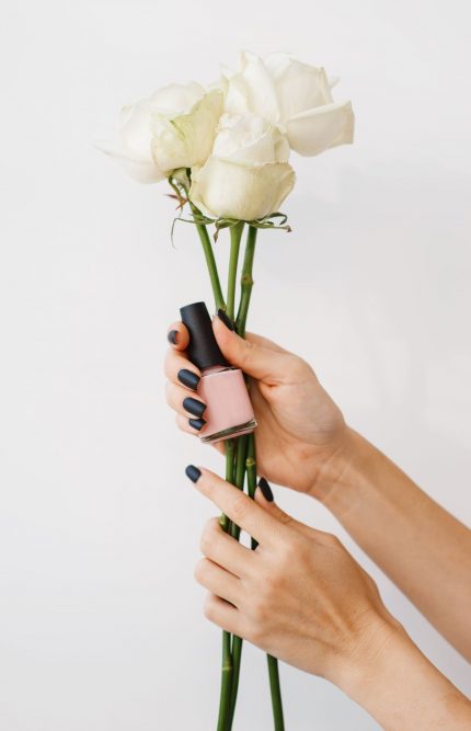 woman-holds-nail-varnish-and-flowers-beauty-salon-U2366SW.jpg